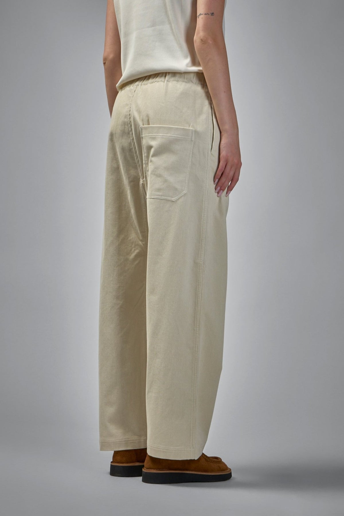 Detail view of elasticated waistband and button closure on cotton pants
