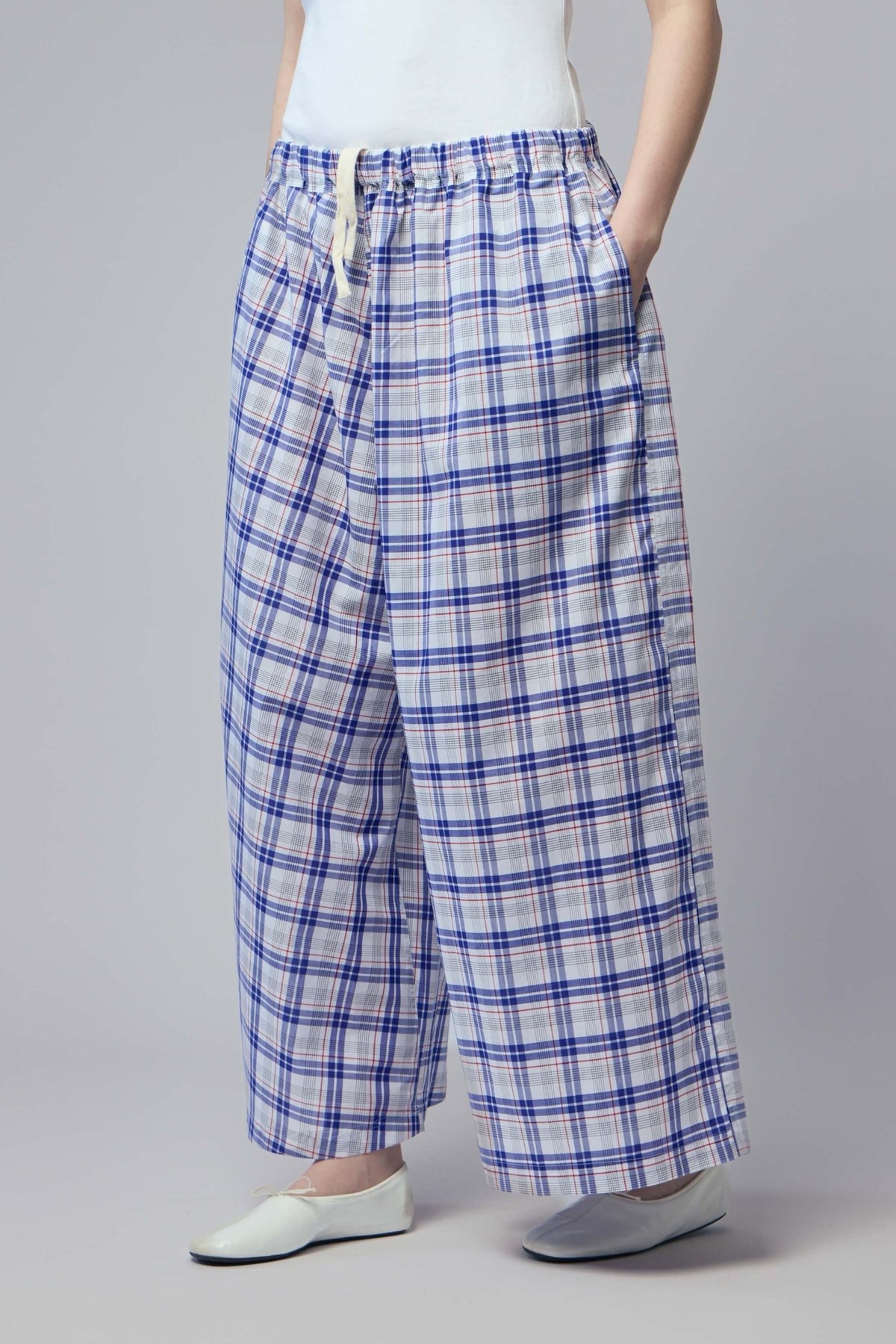 Detail of elasticated waistband with drawstring on cotton plaid pants