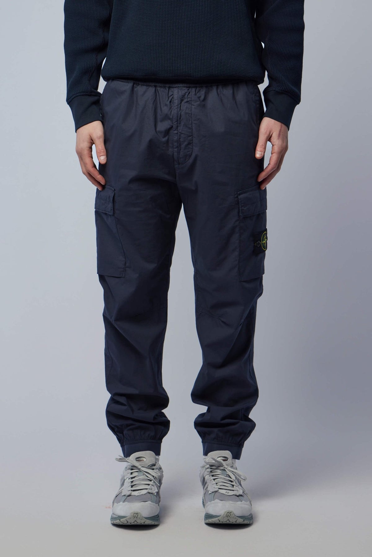 Close-up of Stone Island compass logo patch on cargo pants pocket