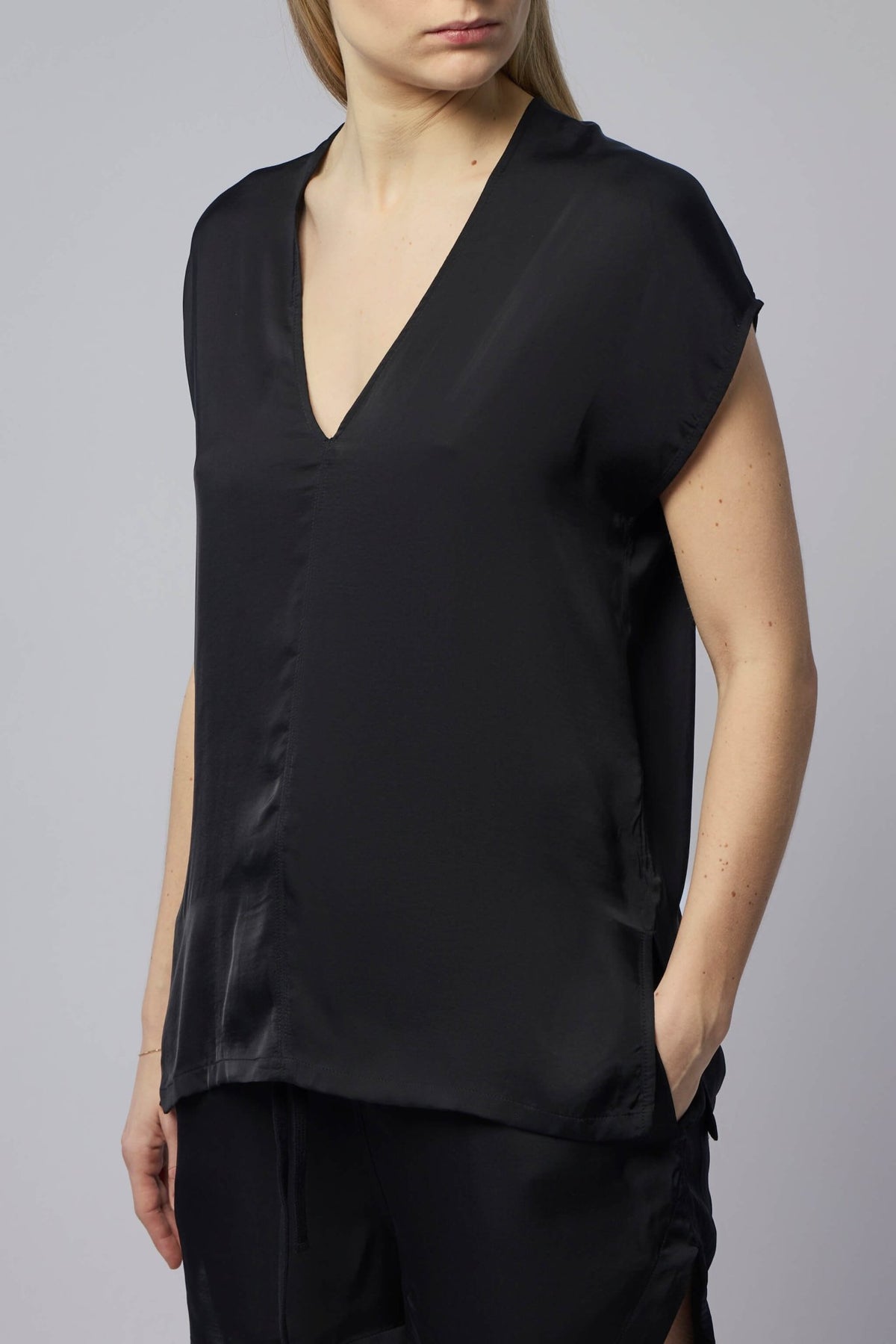 Model wearing Thom Krom black V-neck blouse with relaxed fit