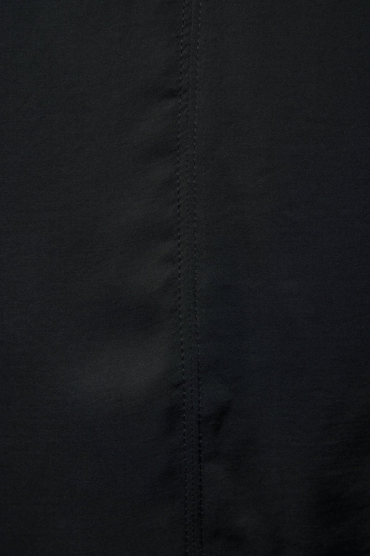 Back view of women's black blouse with straight hemline