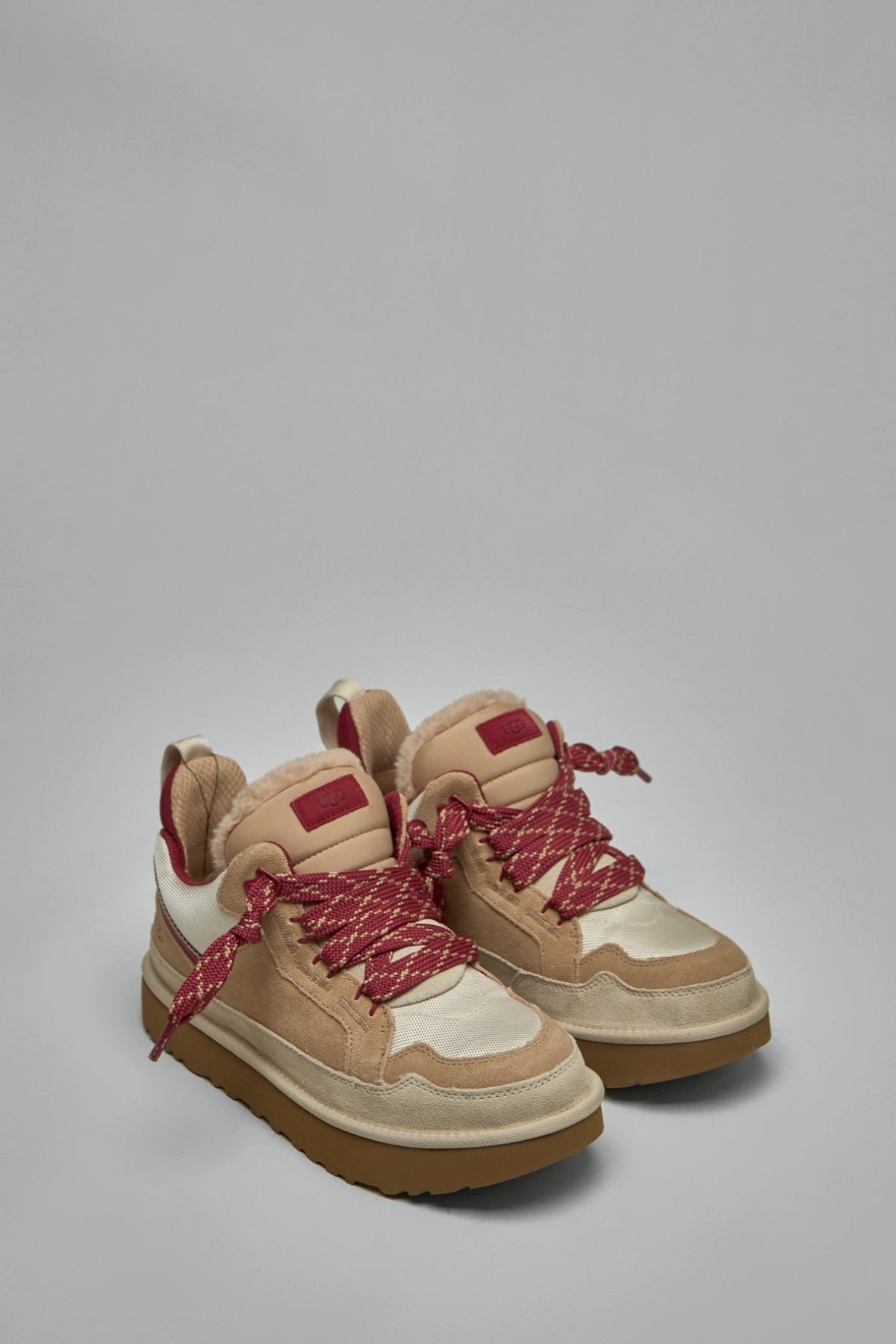 Side view of UGG Lowmel sneakers showing thick gum sole and premium leather upper