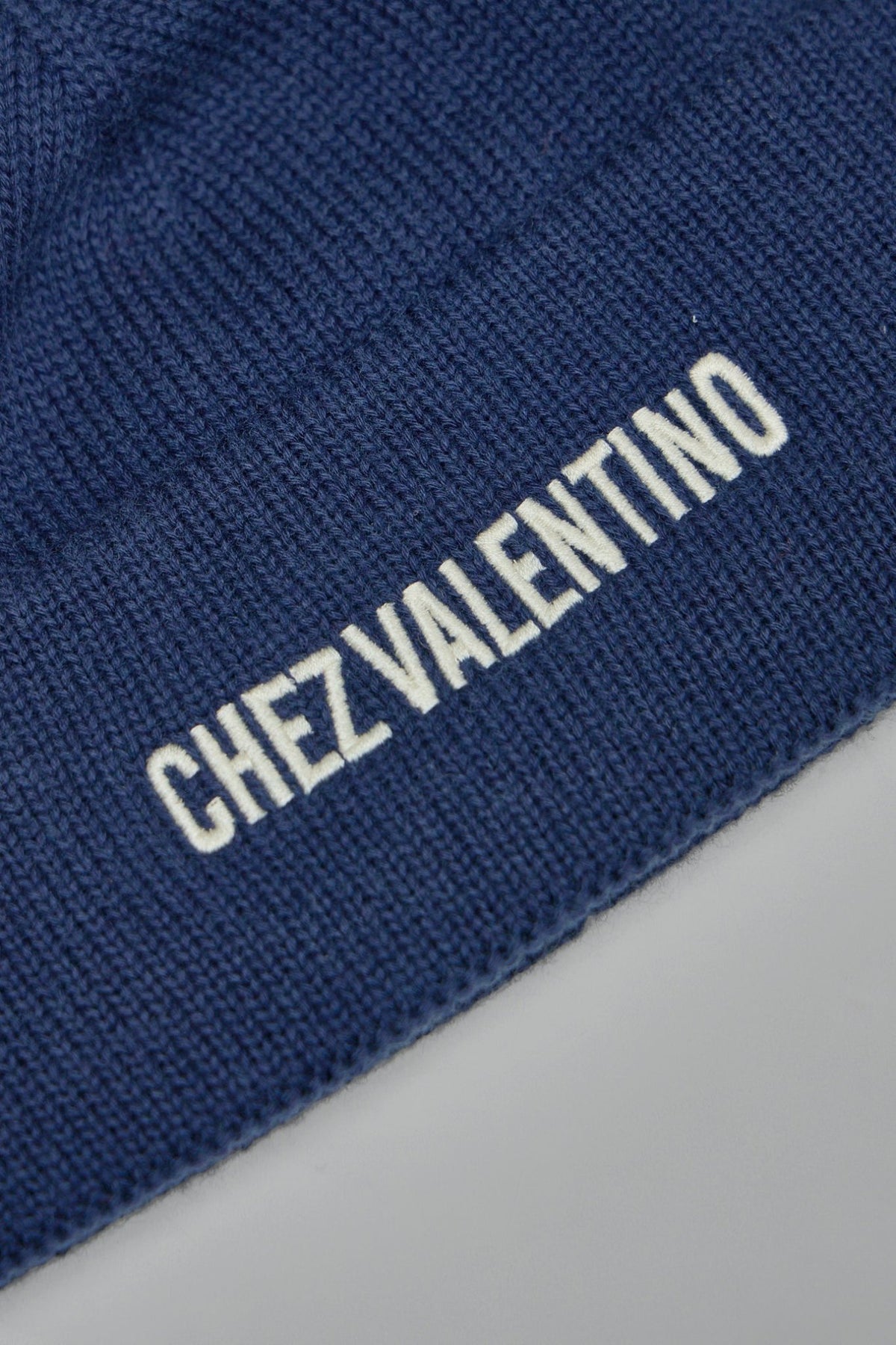 Side view of Valentino logo embroidered beanie showing folded cuff design