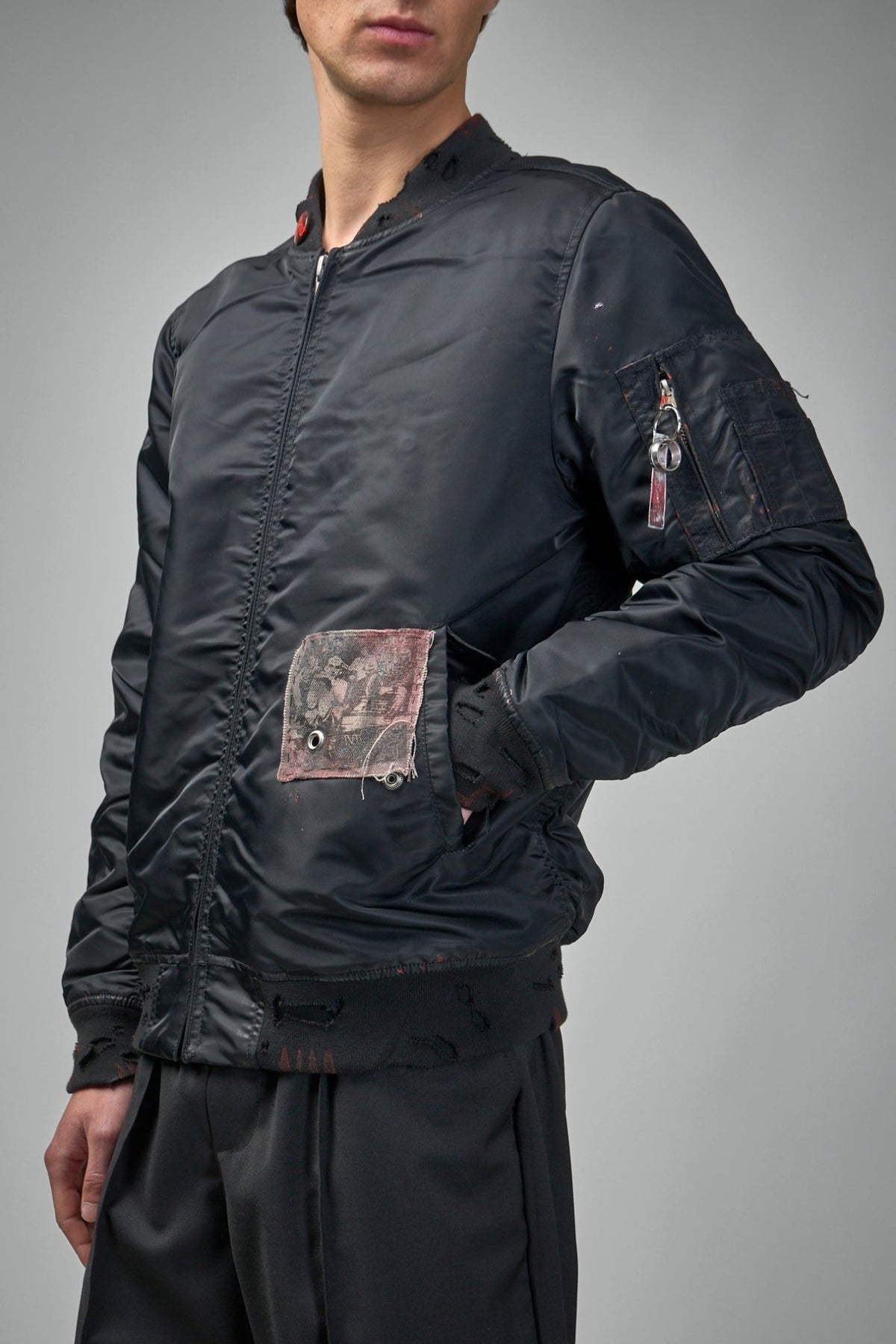 Back view of black nylon bomber jacket showing craftsmanship details