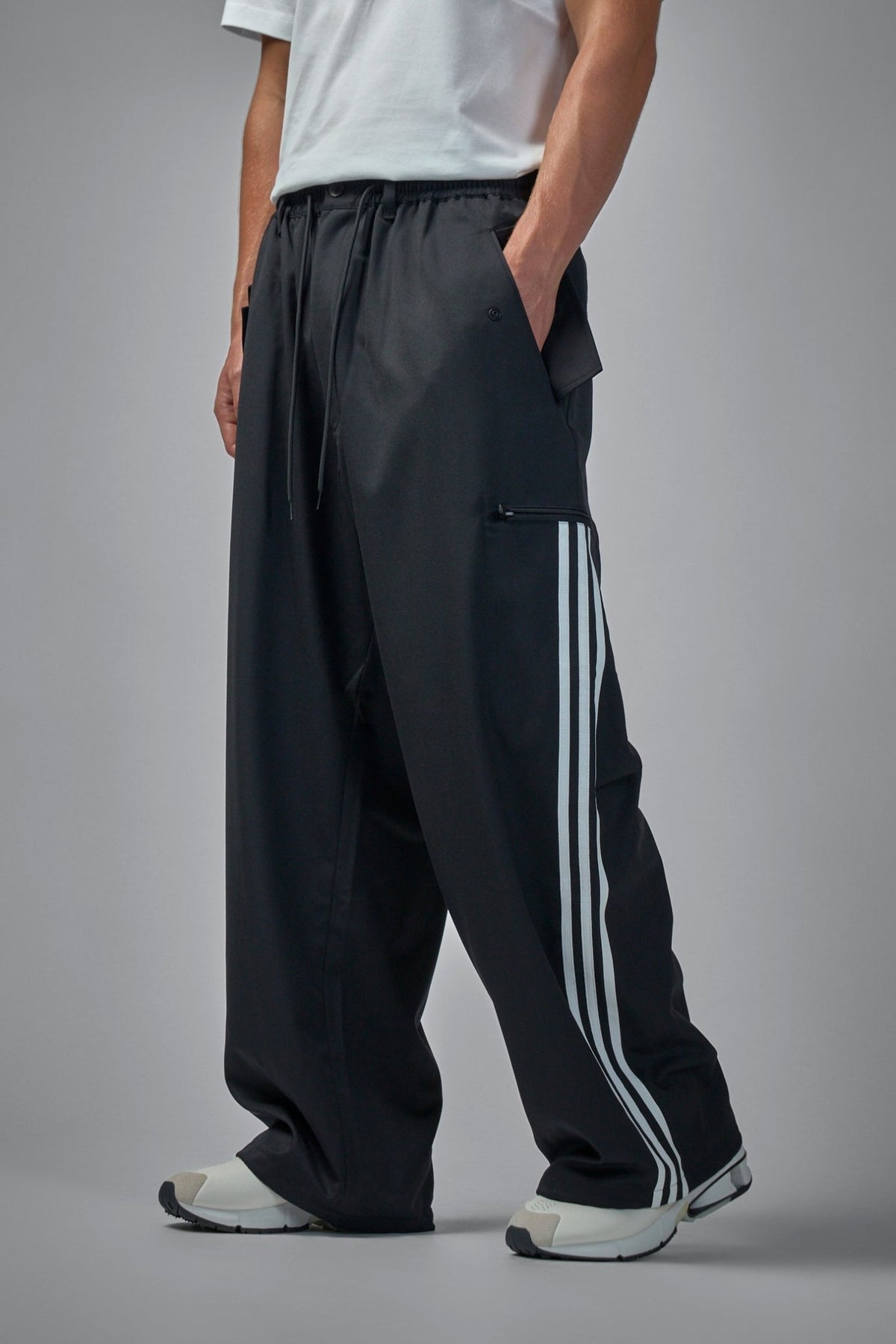 Side view of cuffed track pants displaying relaxed wide-leg silhouette