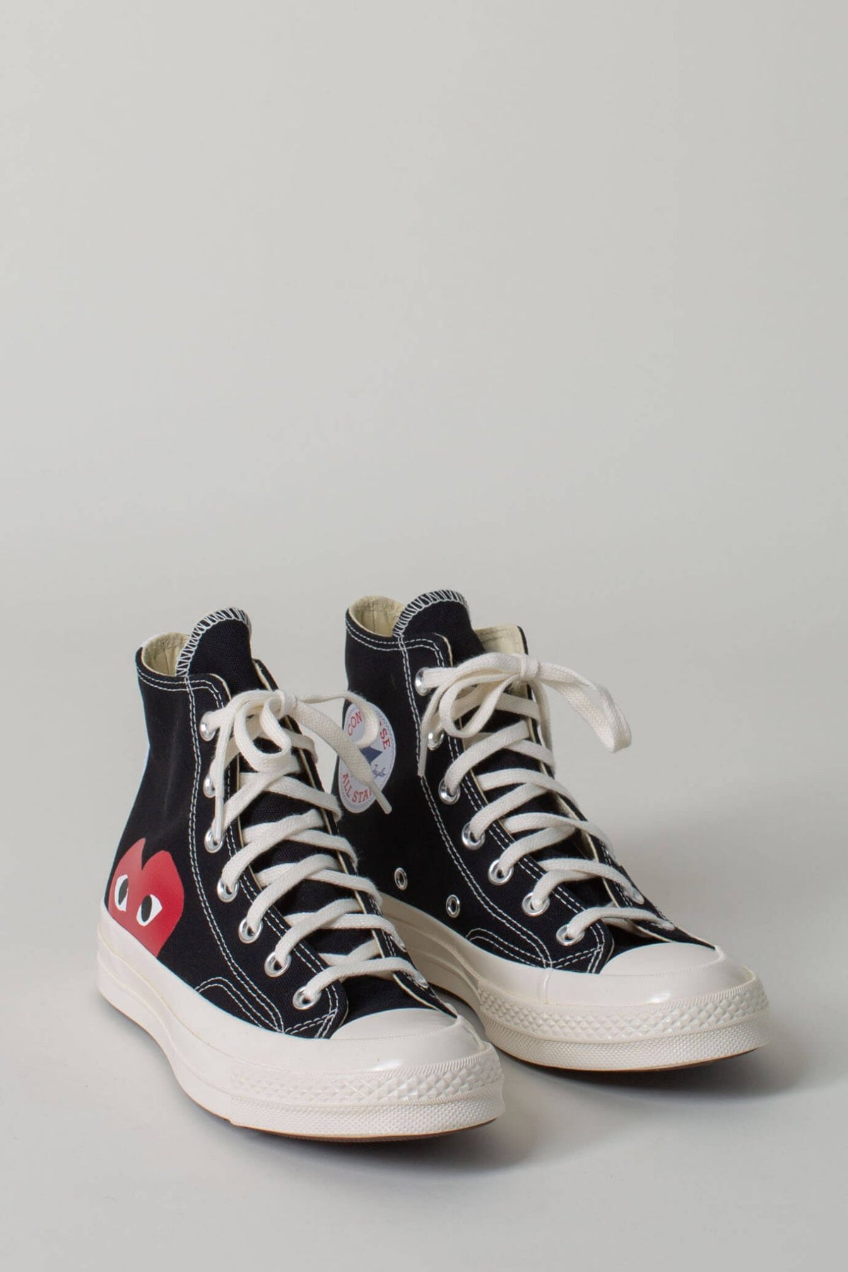 Side view of CDG PLAY Converse high tops showing iconic heart emblem