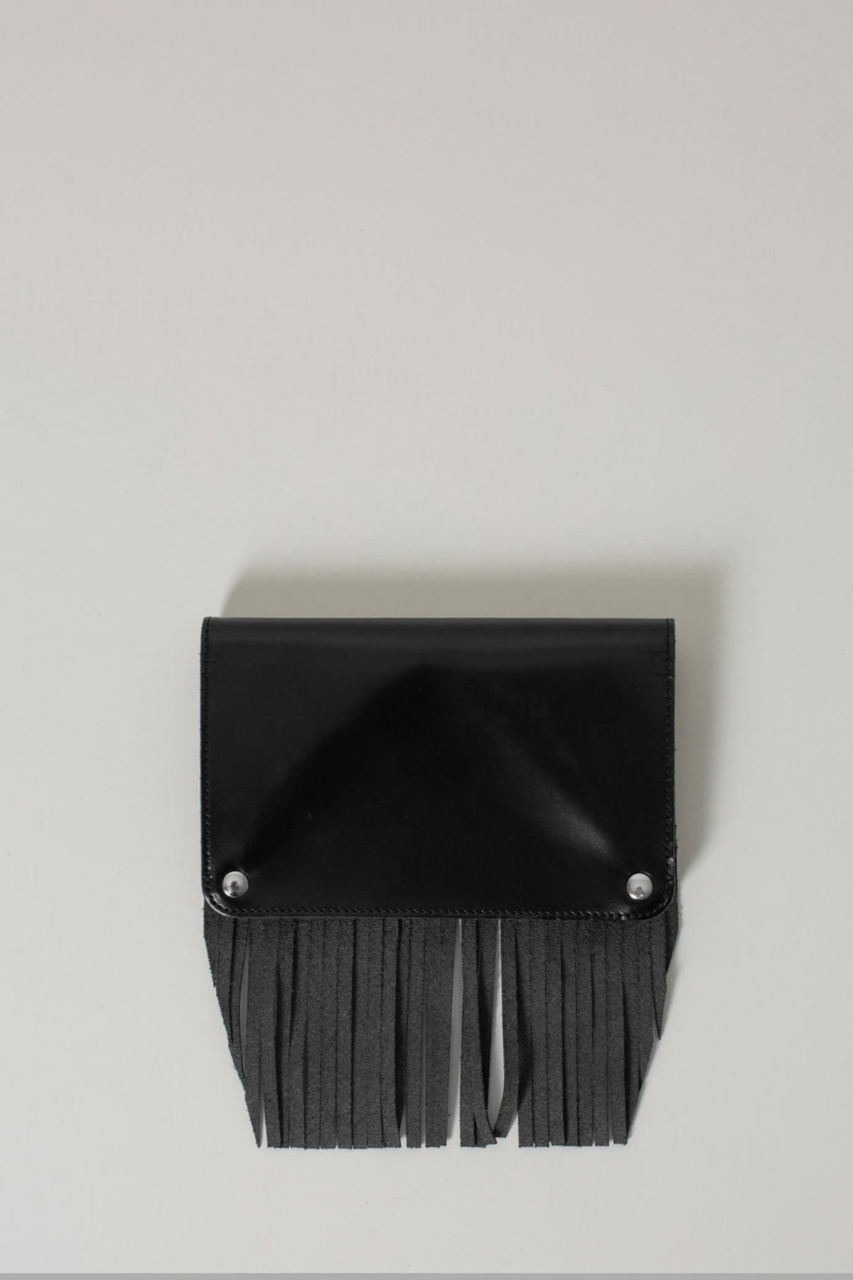 Close-up detail of fringe texture on black Comme des Garçons wallet